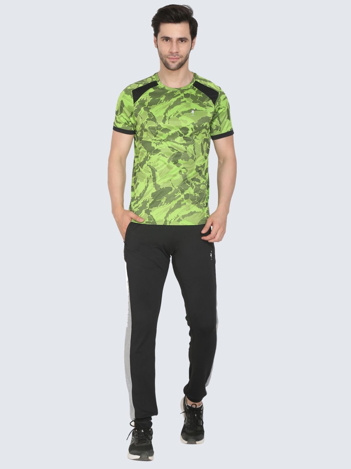 Full-body male model wearing neon green camo T-shirt with black shoulder panels on a white background