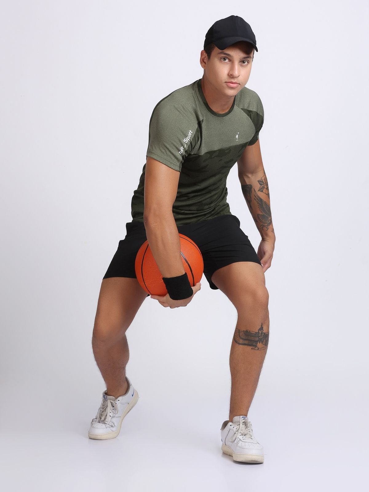 Action stance of a man wearing an olive camo athletic t-shirt and black shorts.