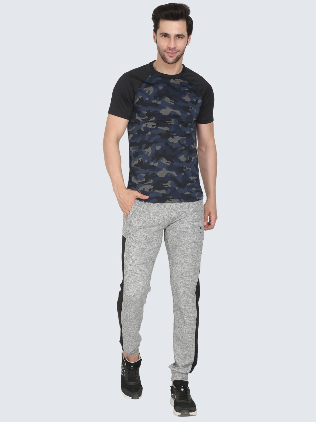 Full-body male model wearing navy camo raglan T-shirt and grey joggers on a white background