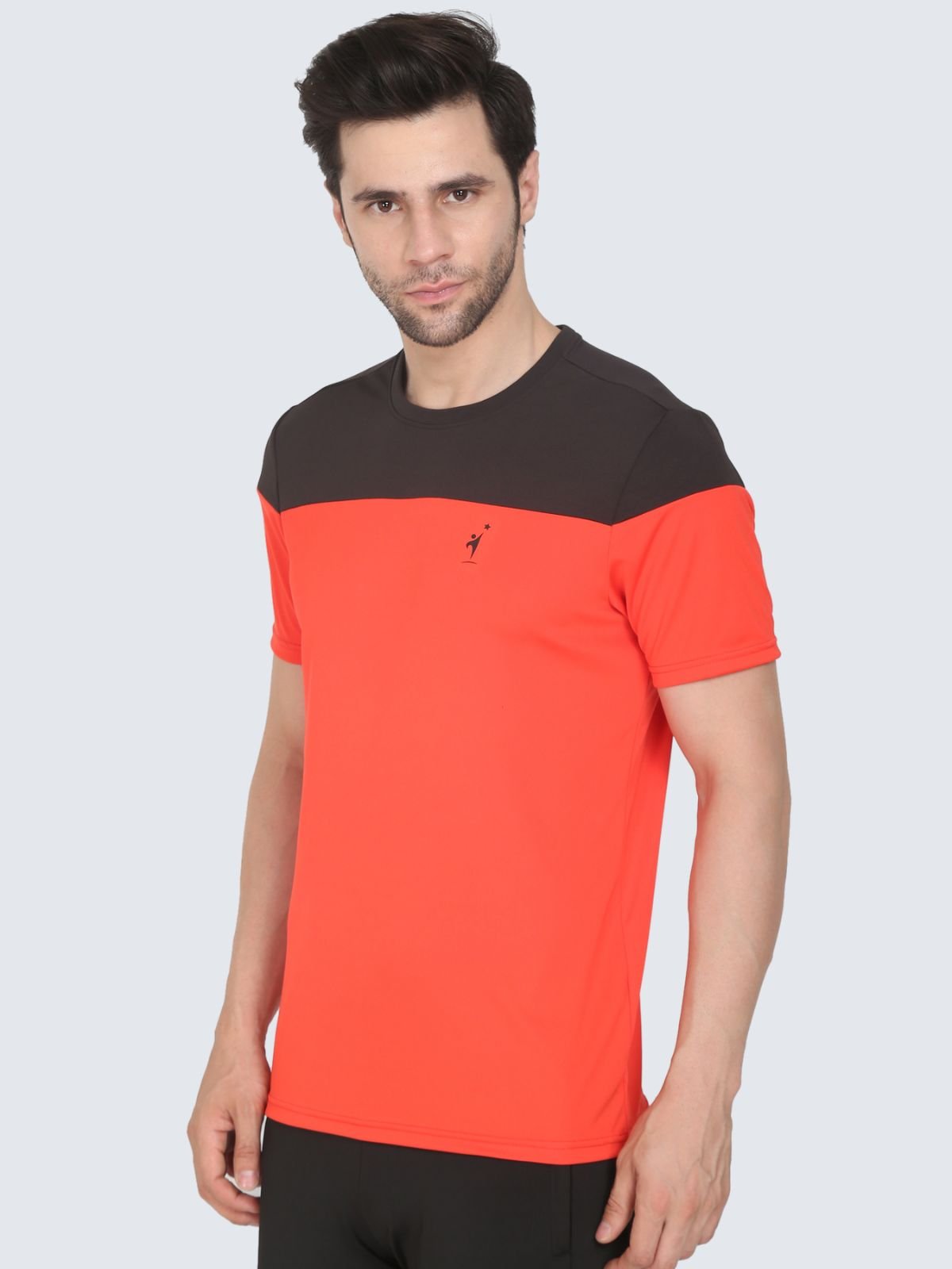 Three-quarter view of tomato red ClubSpirit T-shirt with black yoke and NDR SPORT logo on a white background