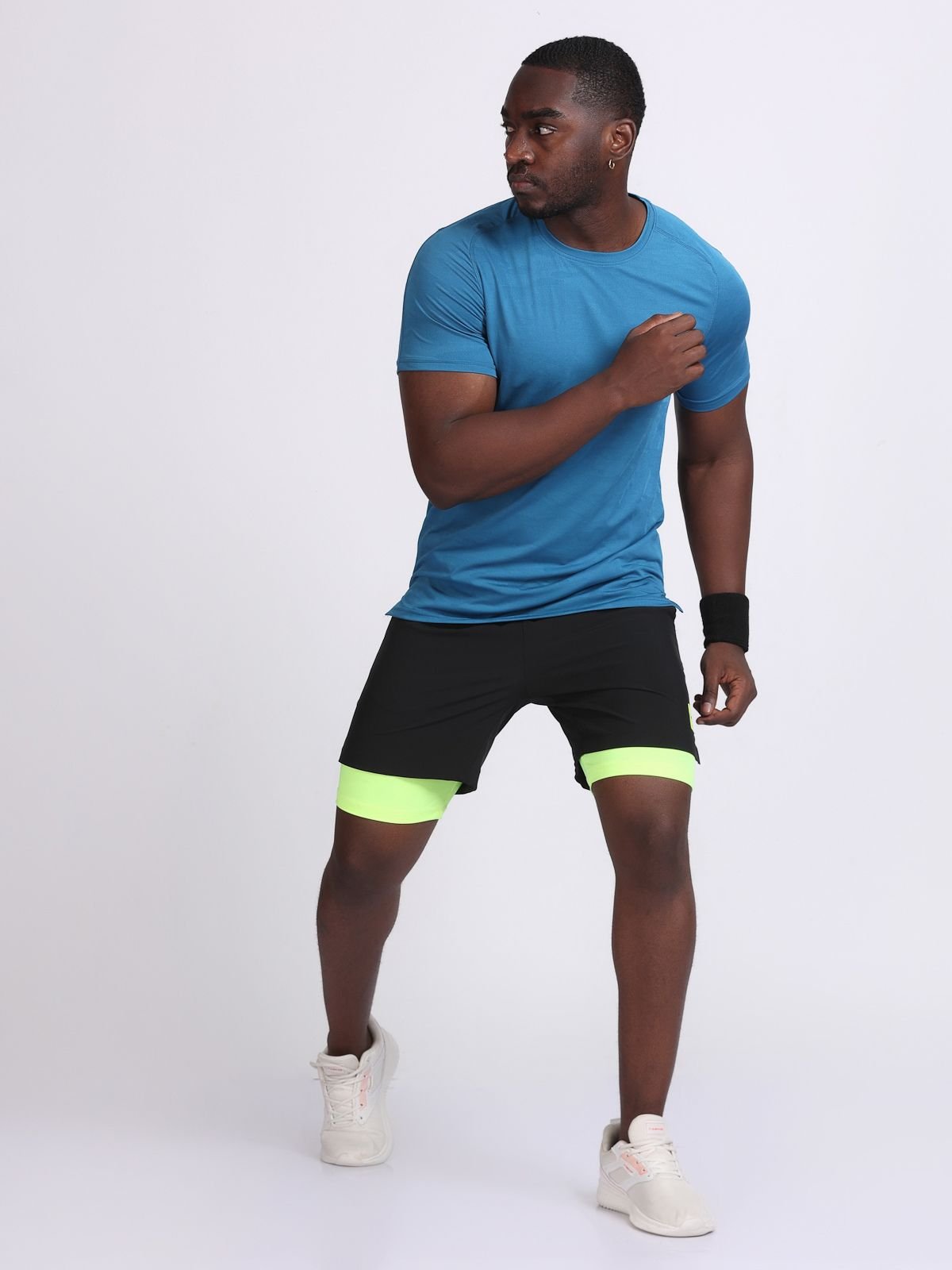 Action pose of a man wearing a teal JaqMesh athletic t-shirt and black shorts of NDR SPORT.