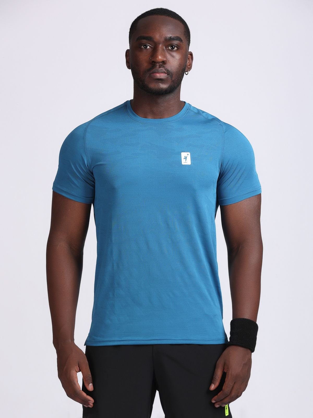Front view of a man wearing a teal JaqMesh t-shirt.