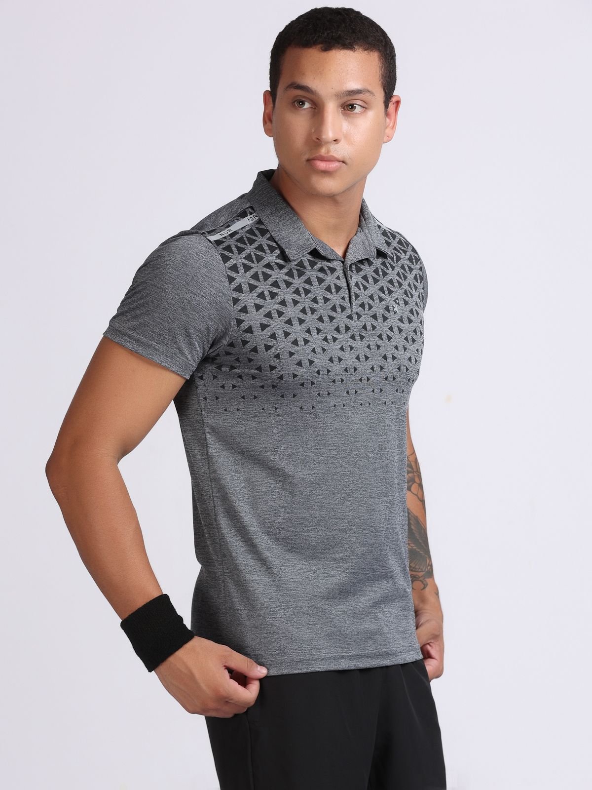 Male model wearing dark grey geometric-print polo T-shirt Milanz Illustrated, right-facing view