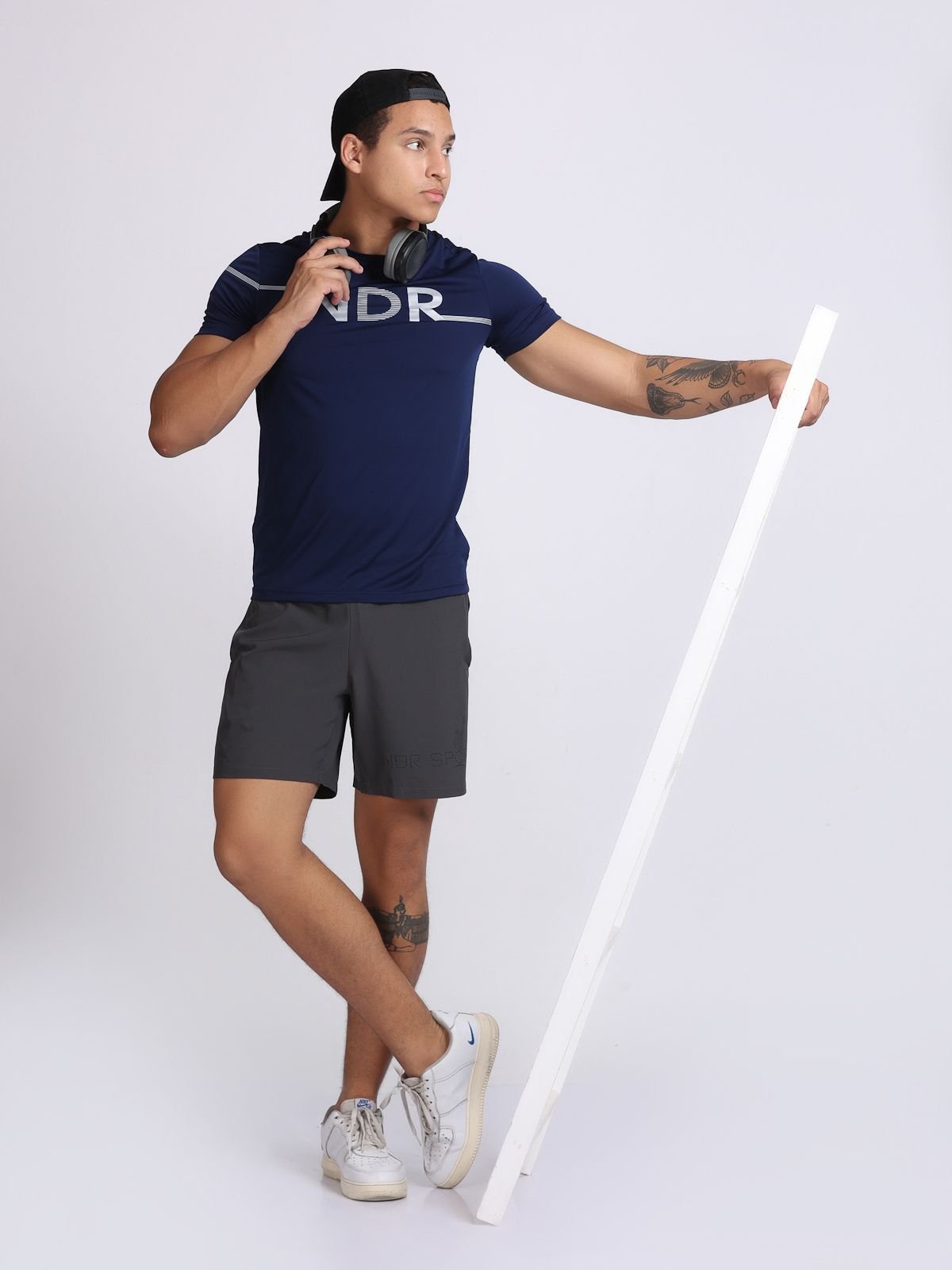 Action pose of a man wearing a navy NDR Blitz t-shirt and headphones.