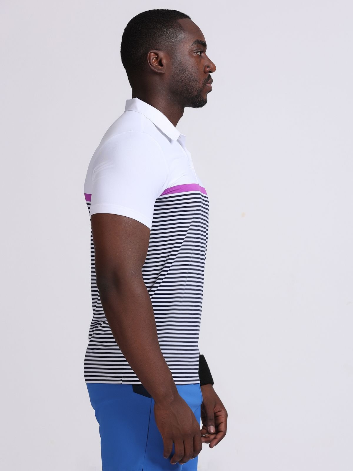 Side view of a man wearing a white striped polo t-shirt Streifen with purple accent stripe.